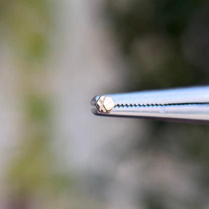 14k gold threadless end from tether jewelry, hexagon with detailing, tragus piercing, lobe piercing, helix cartilage piercing, nose piercing. Solid gold threadless end. 