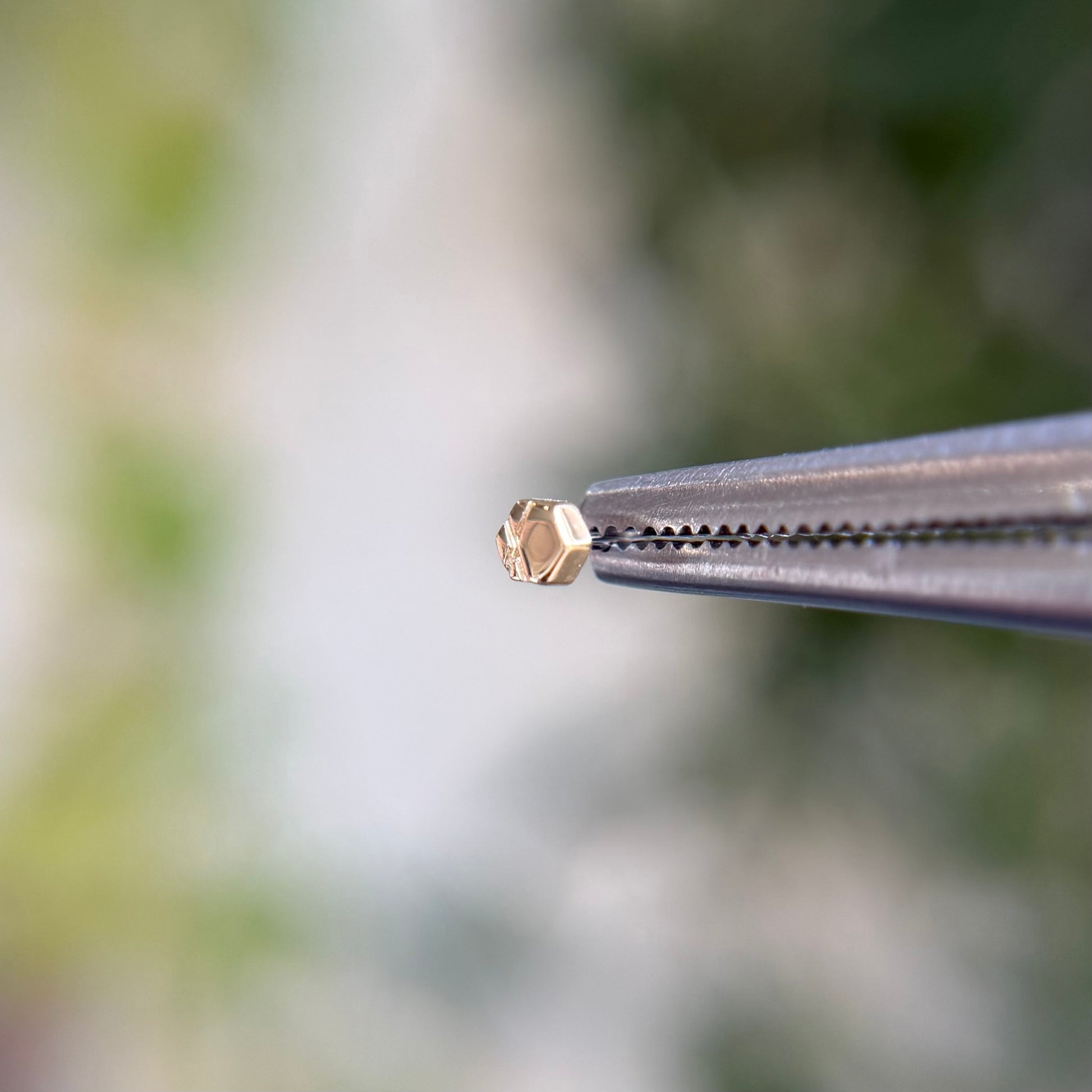 14k gold threadless end from tether jewelry, hexagon with detailing, tragus piercing, lobe piercing, helix cartilage piercing, nose piercing. Solid gold threadless end. 