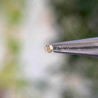 14k gold threadless end from tether jewelry, hexagon with detailing, tragus piercing, lobe piercing, helix cartilage piercing, nose piercing. Solid gold threadless end. 